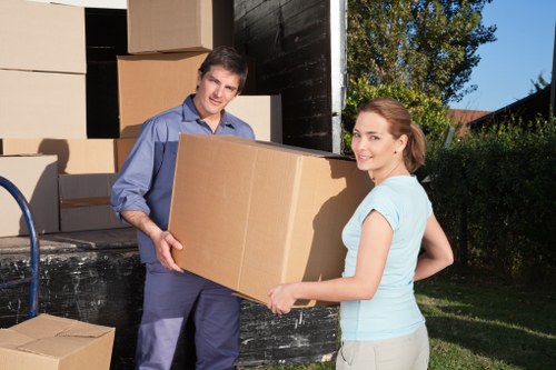 Expert movers handling fragile items during packing in Acton